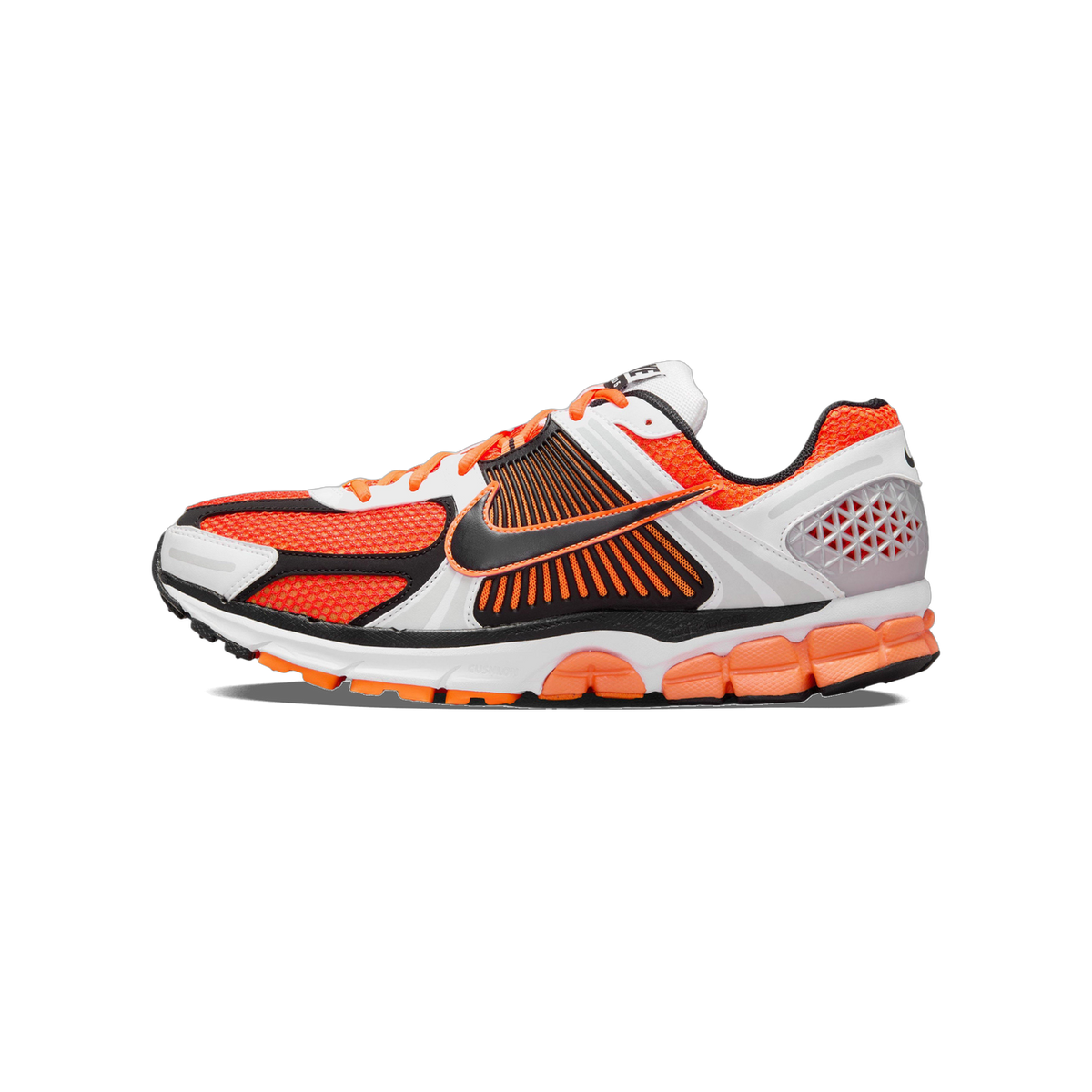 Side view of a Nike Zoom Vomero 5 running shoe in orange, white, black, and silver with mesh upper and segmented midsole, toe pointing left.