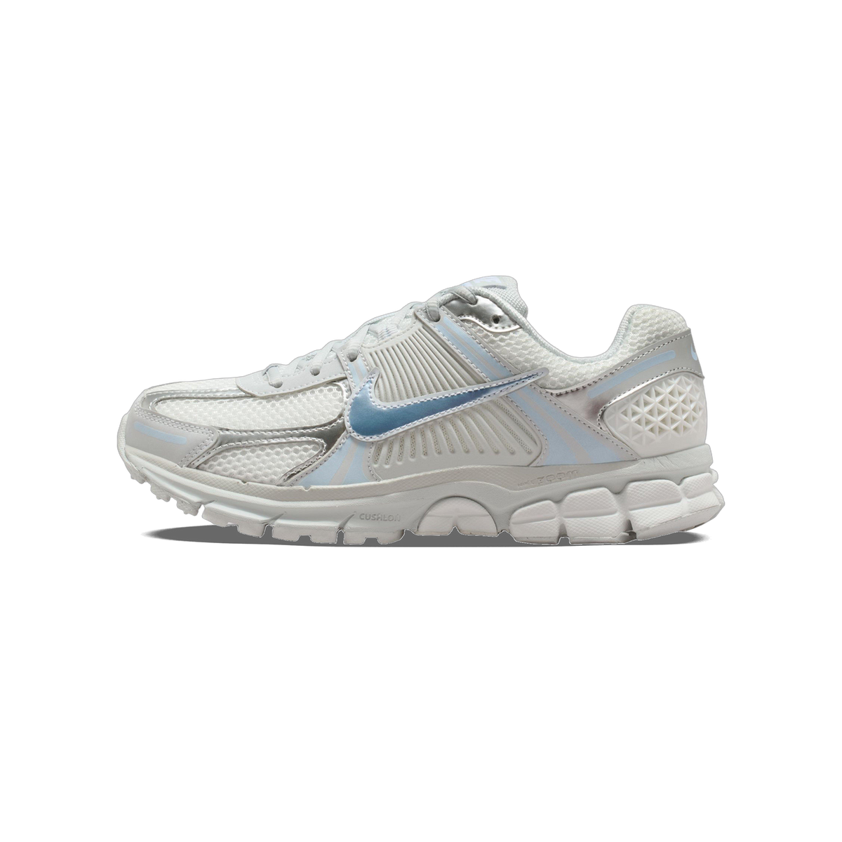 Side view of a white and silver Nike Zoom Vomero 5 running shoe with a light blue Swoosh and chunky ridged outsole, toe pointing left