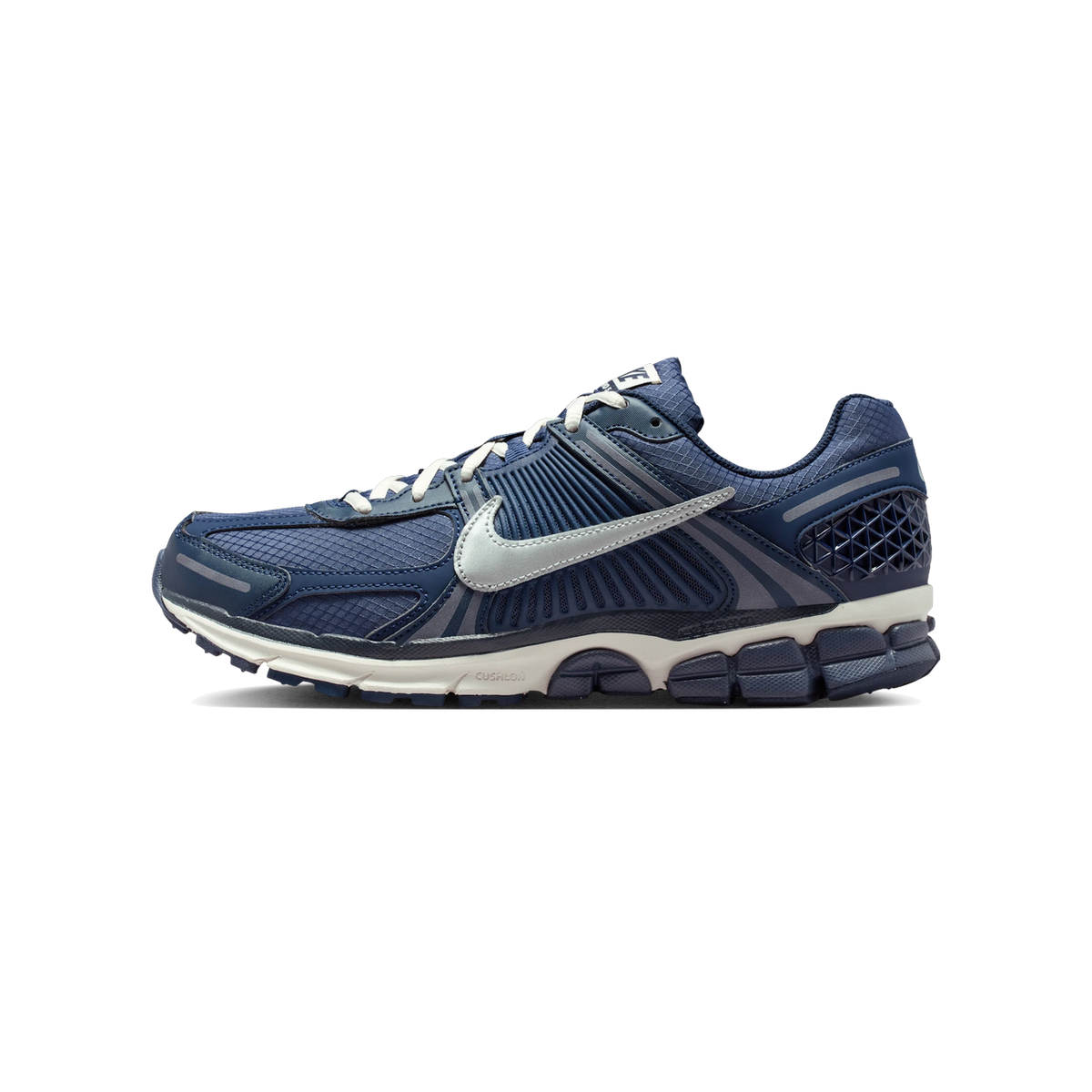 Left navy blue Nike Zoom Vomero 5 running shoe shown from the side with toe pointing left, featuring a white swoosh and cream midsole