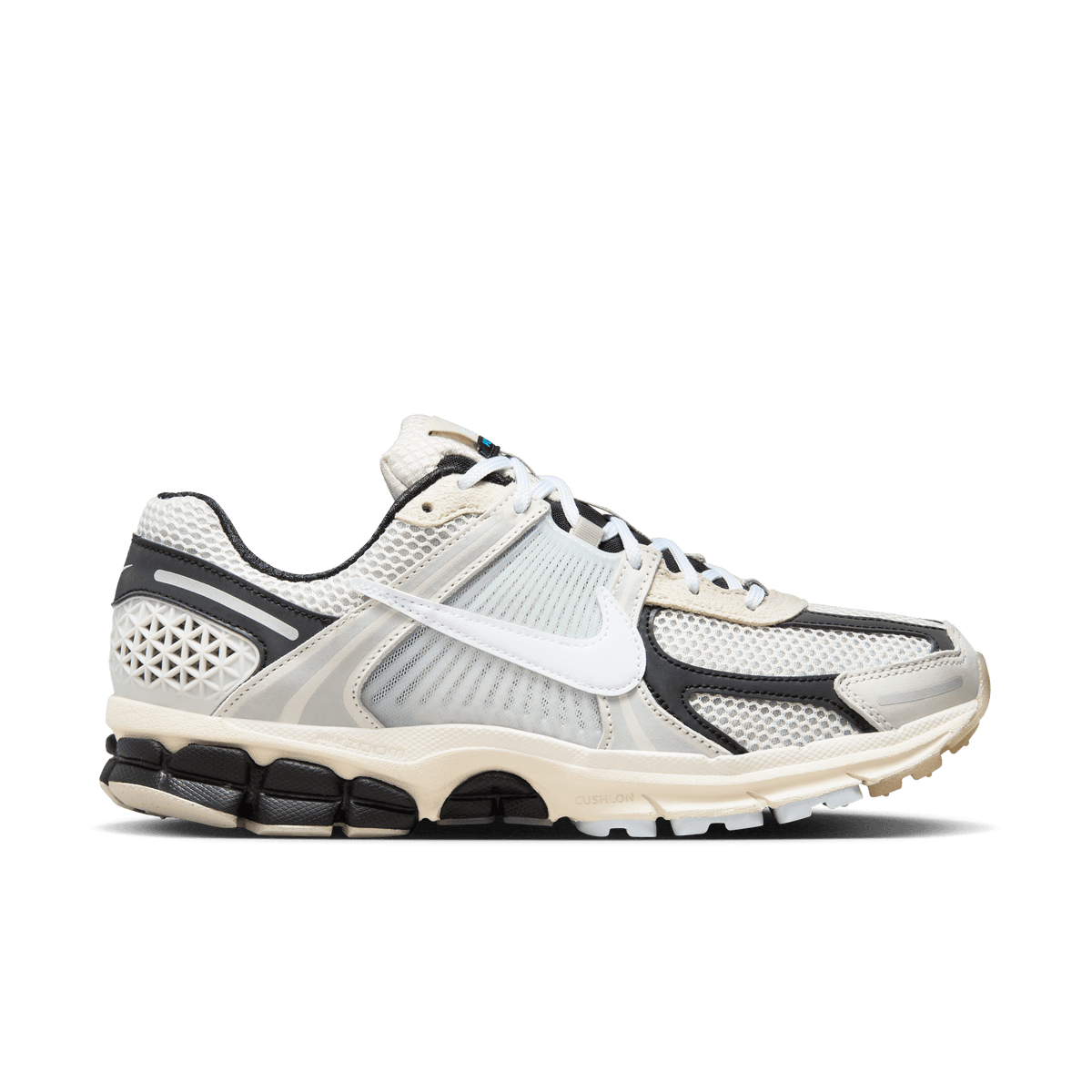 Lateral view of a Nike Zoom Vomero 5 sneaker in light bone and black with mesh upper, white swoosh, and segmented black midsole with cream Cushlon detailing