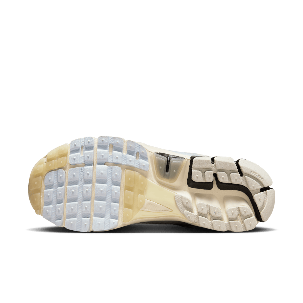Bottom view of a Nike Zoom Vomero 5 sneaker showing a light bone and black textured rubber outsole with segmented tread pattern.