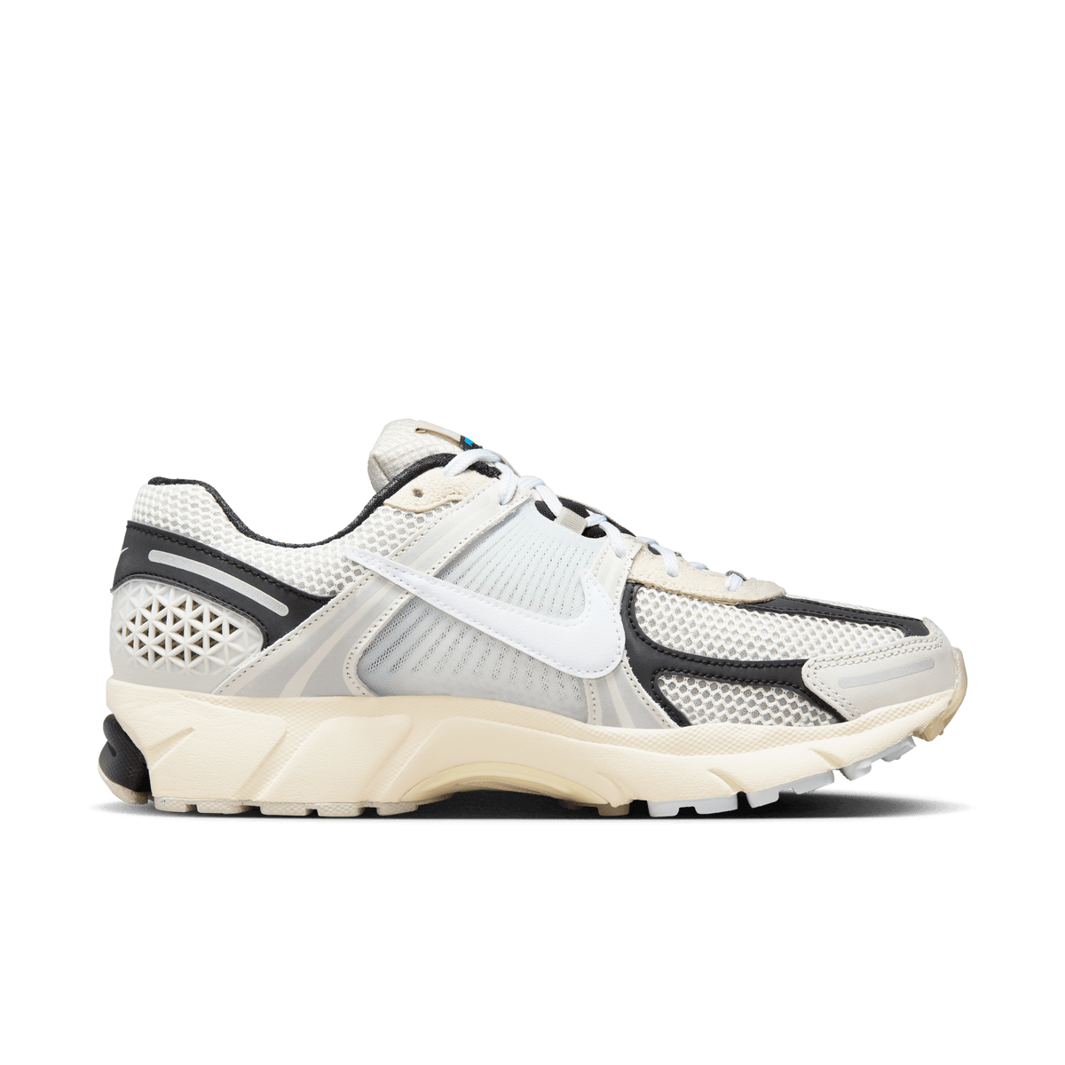 Lateral view of a Nike Zoom Vomero 5 sneaker in light bone, grey and black with a white swoosh and cream midsole