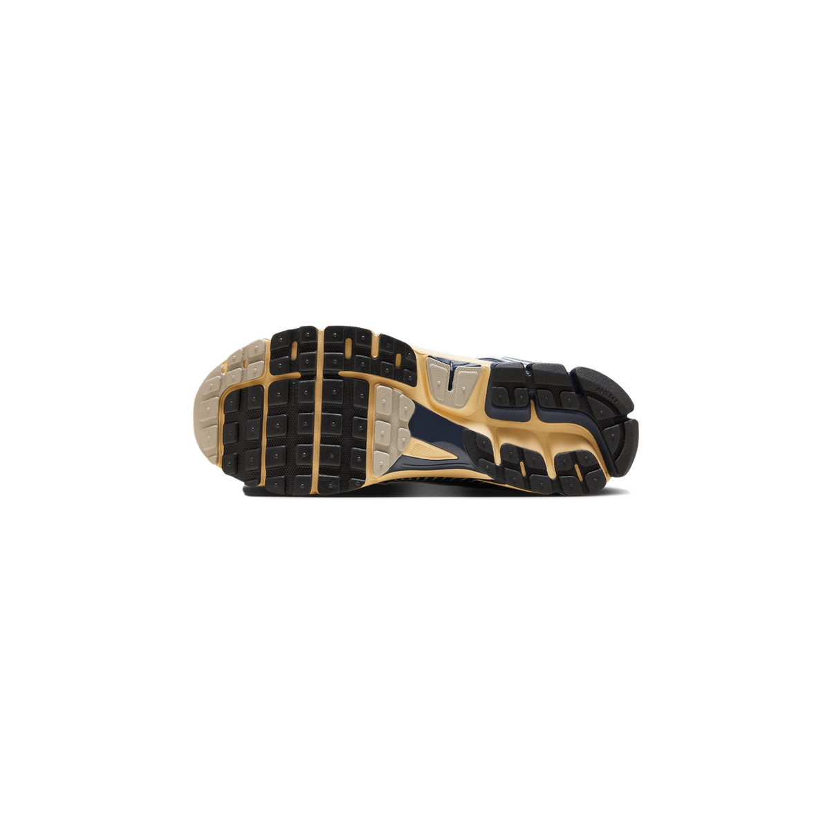 Bottom view of a Nike Zoom Vomero 5 sneaker showing black tread lugs with cream and navy outsole accents