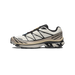 Side view of a white Salomon XT-6 trail shoe with black overlays, tan midsole trim, quick-lace toggle, and multicolored lace loops, toe pointing left.