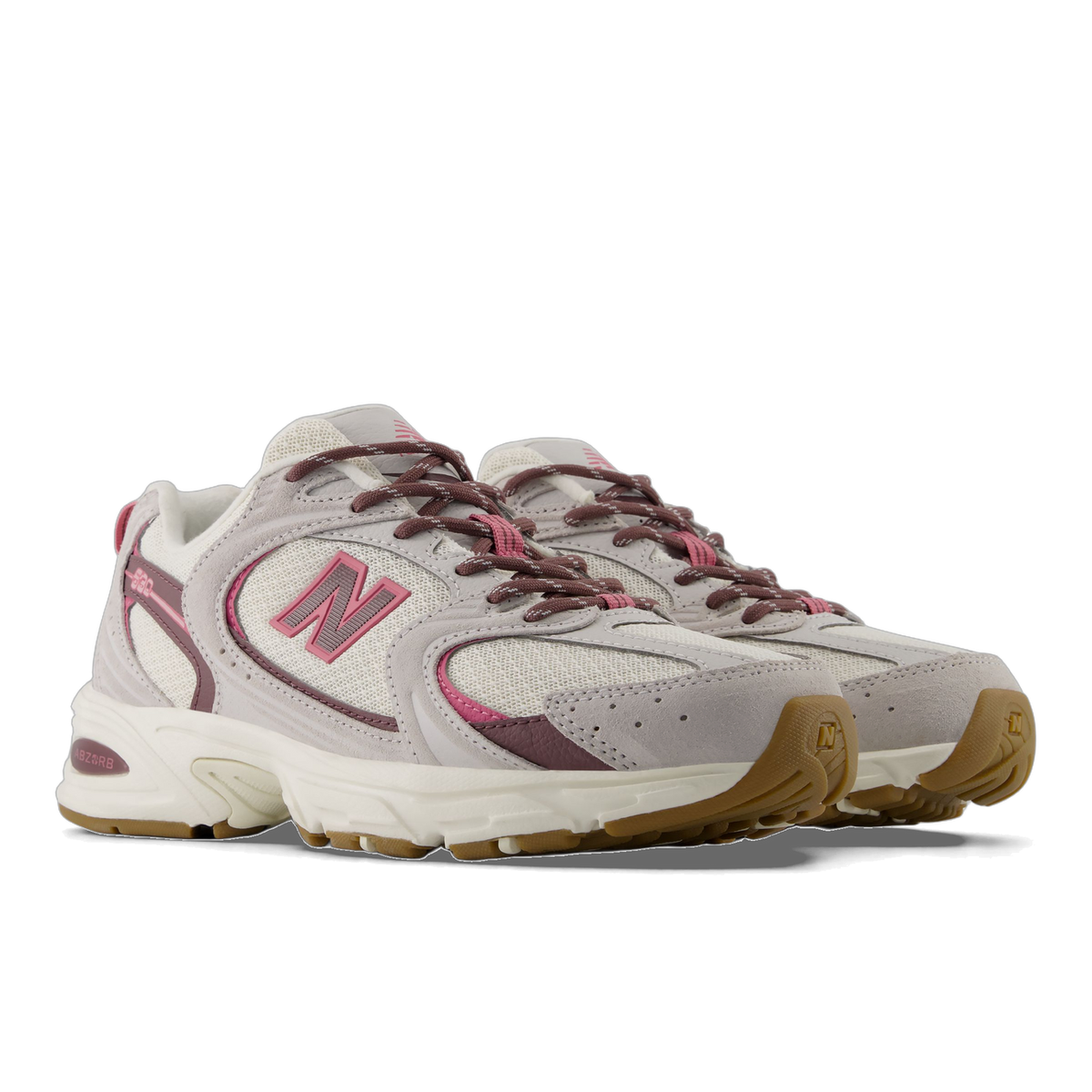 Pair of New Balance U5302V3 sneakers in gray and off-white with pink N logo and mauve accents, shown at an angle with gum rubber outsoles.