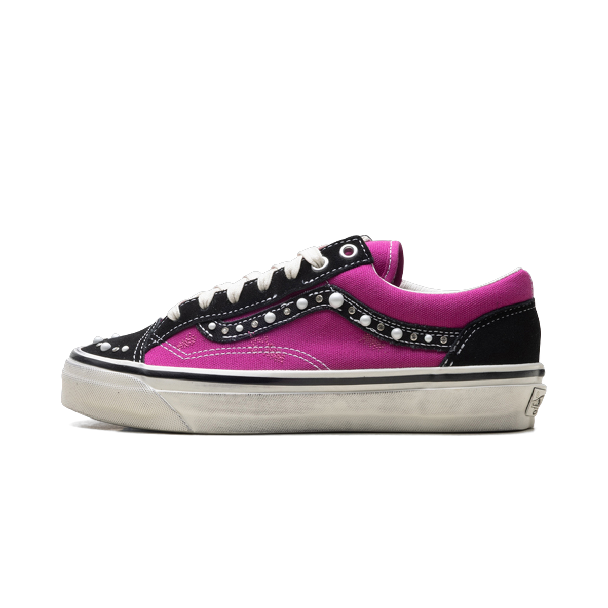 Side view of a pink and black Vans Old Skool-style sneaker with white studs along the sidewall and a white sole.