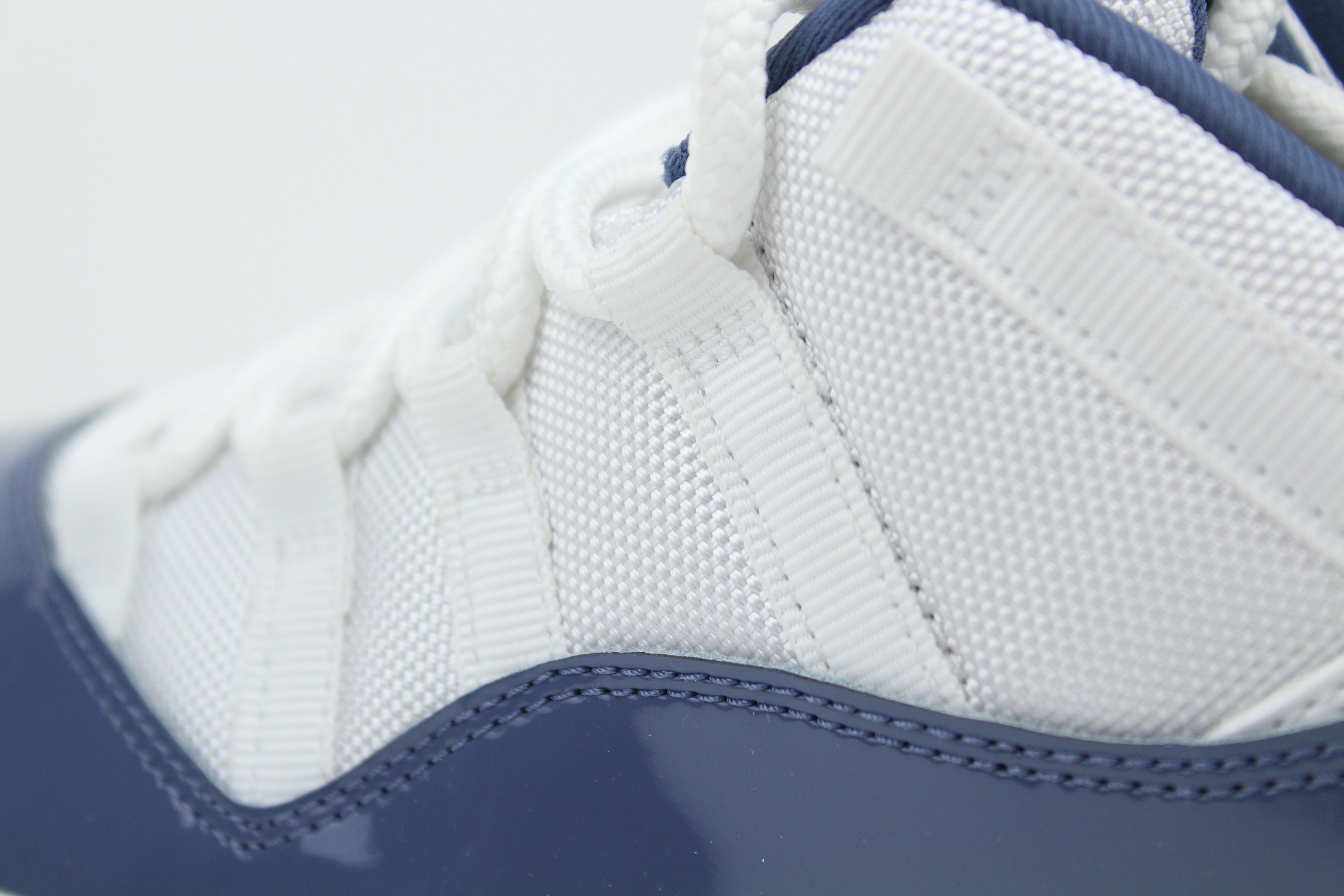 Air Jordan 11 Retro Low Diffused Blue sneakers side view, white leather with blue accents, iconic low-top basketball shoe, premium athletic footwear, stylish and collectible