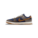 Lateral view of a Nike Dunk Low sneaker with navy corduroy panels, brown tweed toe and heel, houndstooth fabric accents, a tan corduroy Swoosh, cream laces, and a white midsole with gum rubber outsole.