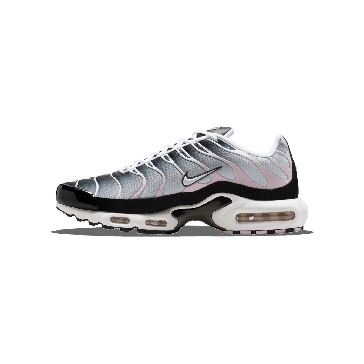 Side view of a Nike Air Max Plus sneaker with a grey wavy upper, pink accents, black toe and heel, white laces, and a visible Air Max cushioning unit in the sole.