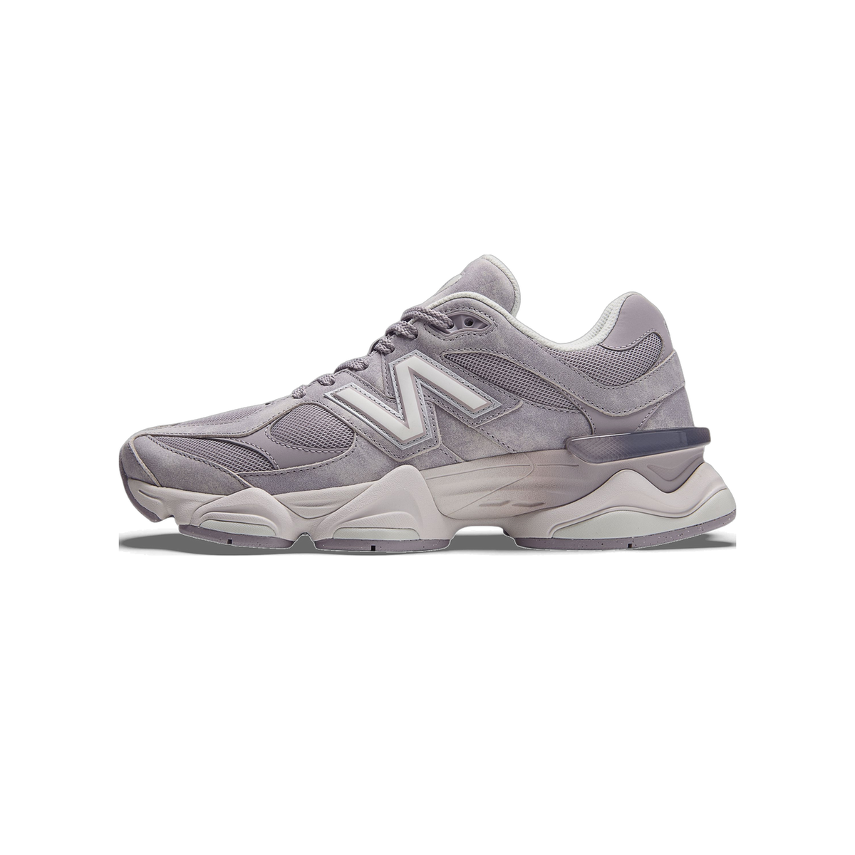 Side view of a grey New Balance 9060 sneaker with white N logo, mesh panels, and chunky two-tone sole, toe pointing left.