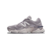 Side view of a grey New Balance 9060 sneaker with white N logo, mesh panels, and chunky two-tone sole, toe pointing left.