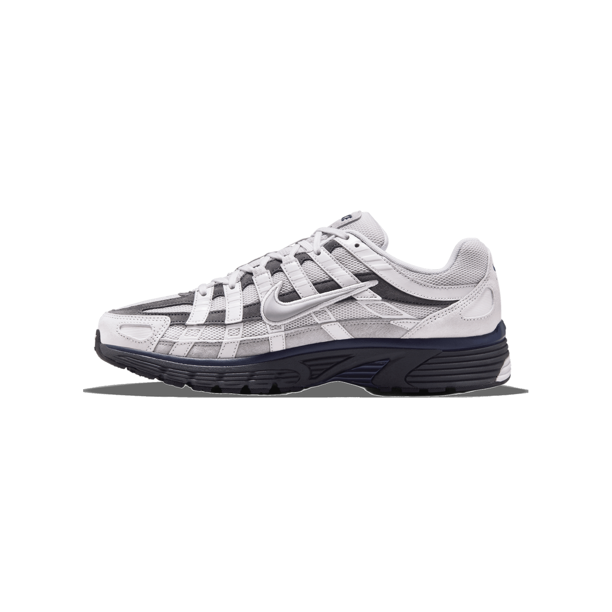 Seitenansicht eines grauen und weißen Nike P-6000 Sneakers mit dunkelblauer Sohle und mehrschichtigem Mesh und Wildleder.