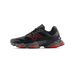 Side view of a black New Balance 9060 sneaker with red N logo, red midsole accents, and a grey chunky outsole, toe pointing left.