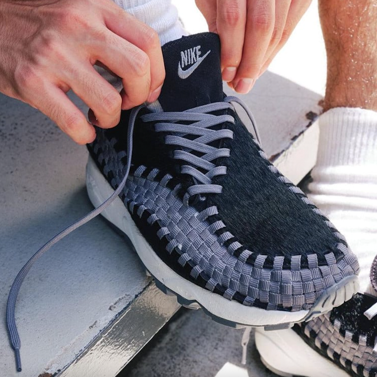Nike Air Footscape Woven Black sneaker with woven side panels and asymmetrical lacing system