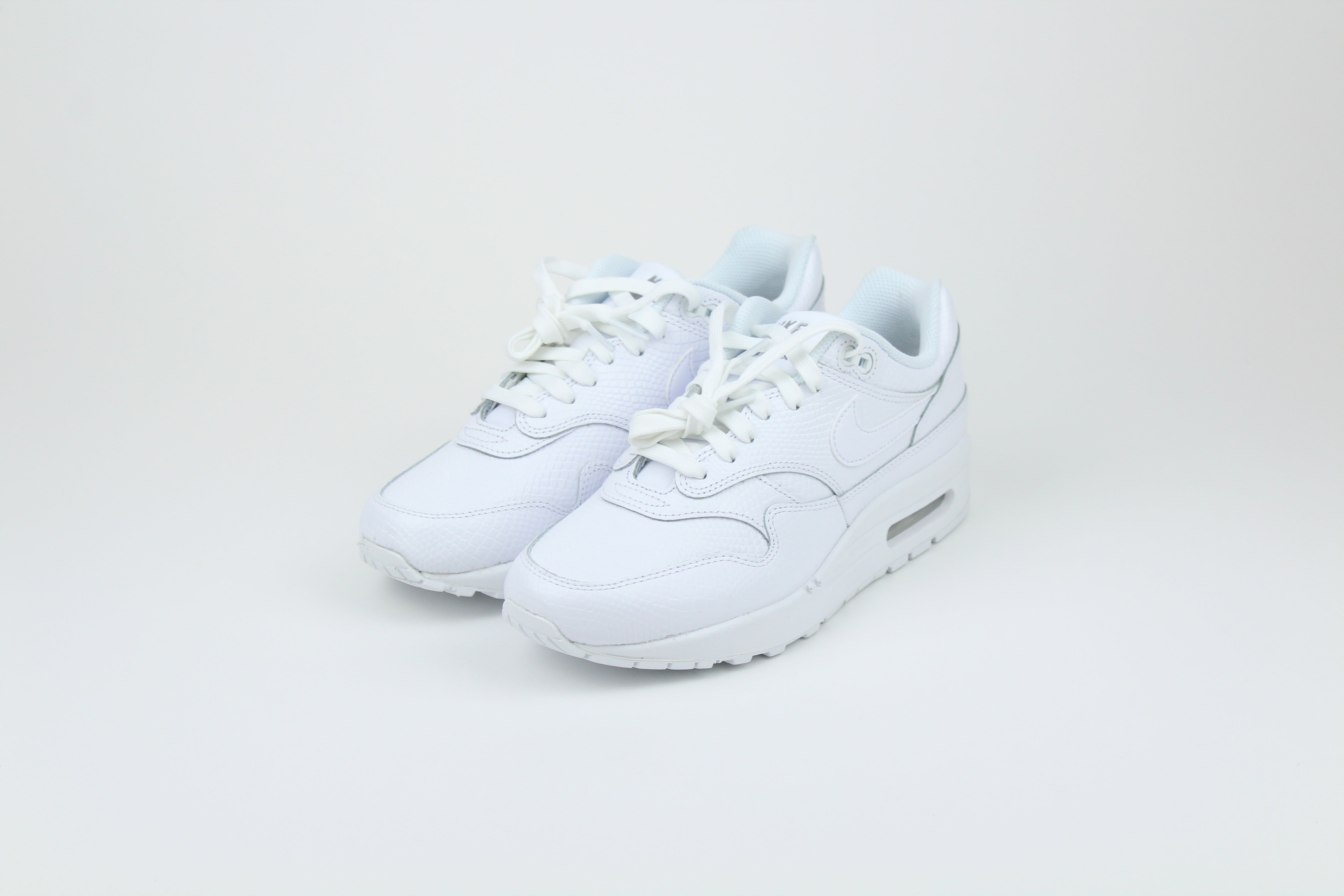 Nike Air Max 1 PRM Snakeskin sneakers in 'Triple White' colorway, premium white athletic shoes with snakeskin detailing, ideal for casual and stylish outfits.