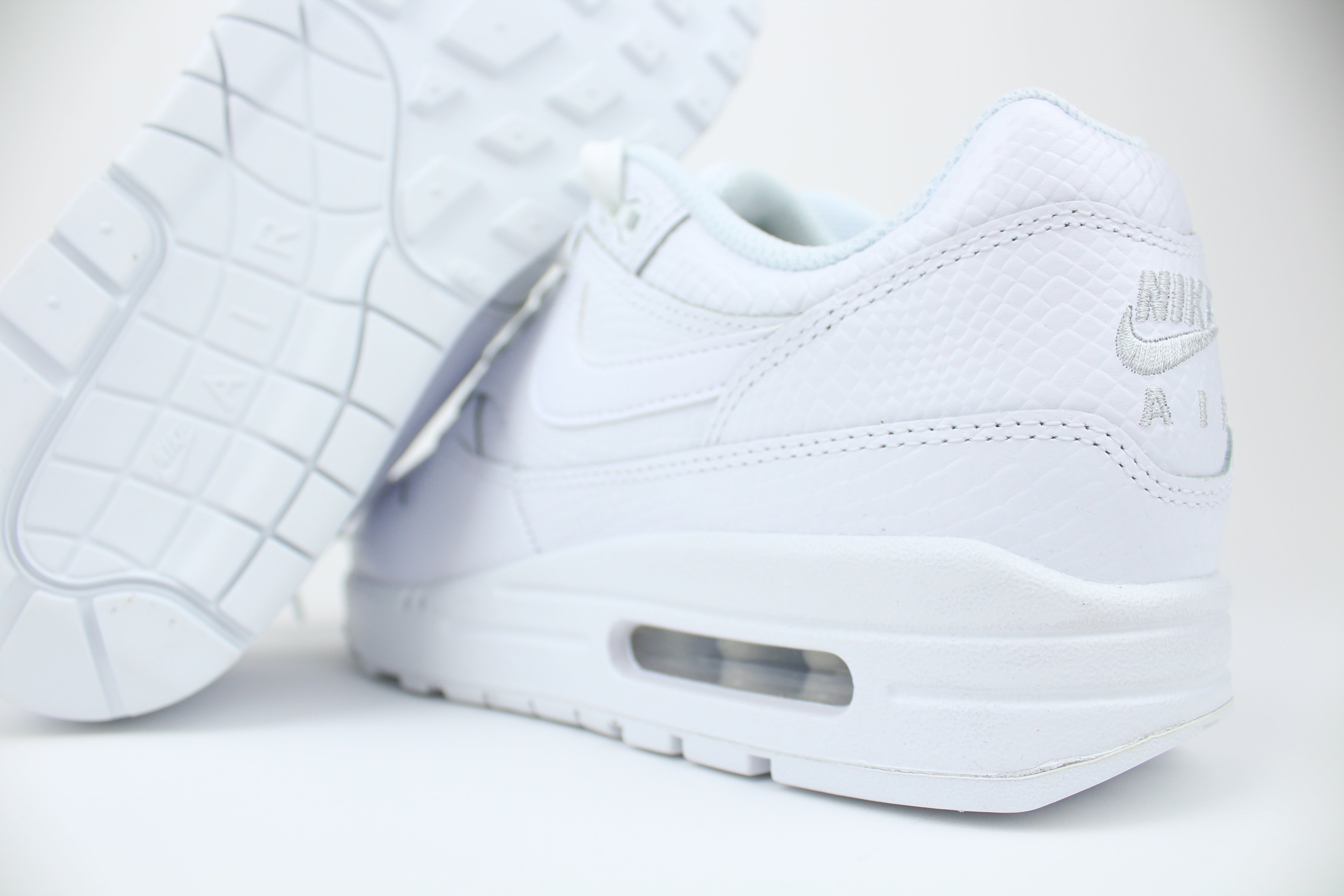 Nike Air Max 1 PRM Snakeskin sneakers in 'Triple White' colorway, premium white athletic shoes with snakeskin detailing, ideal for casual and stylish outfits.