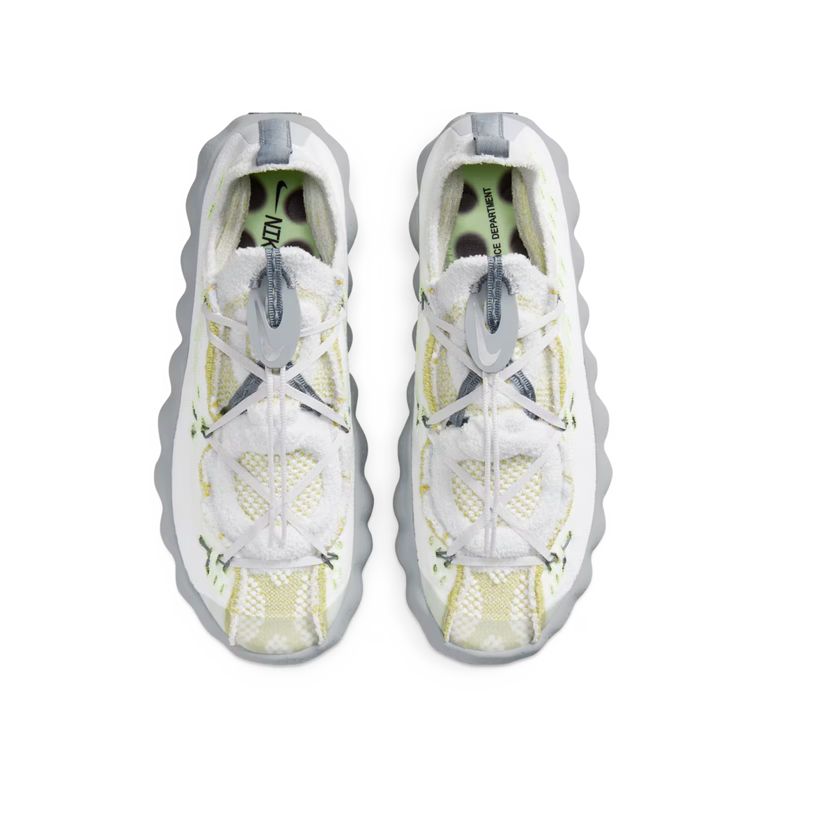 Top-down view of a pair of Nike Mind 002 Flyknit sneakers in white with pale yellow and grey accents, wavy grey outsoles, and grey Nike swoosh logos on crisscrossed laces.