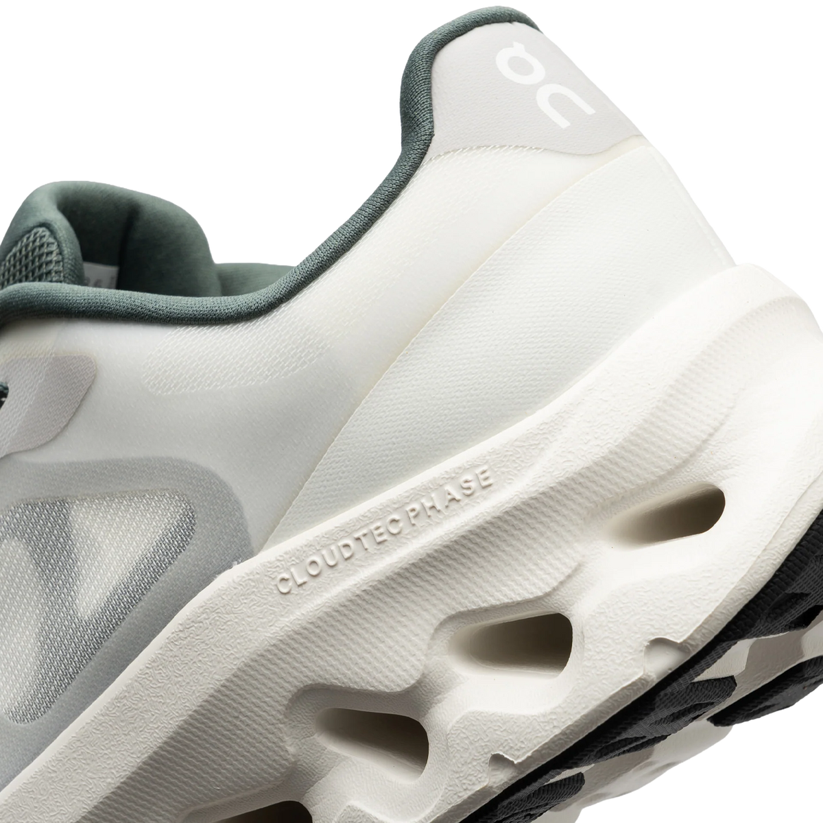 Gros plan sur le talon et l'unité de semelle CloudTec Phase d'une chaussure de running On ivoire et olive, montrant la semelle intermédiaire texturée et les plots d'amorti perforés