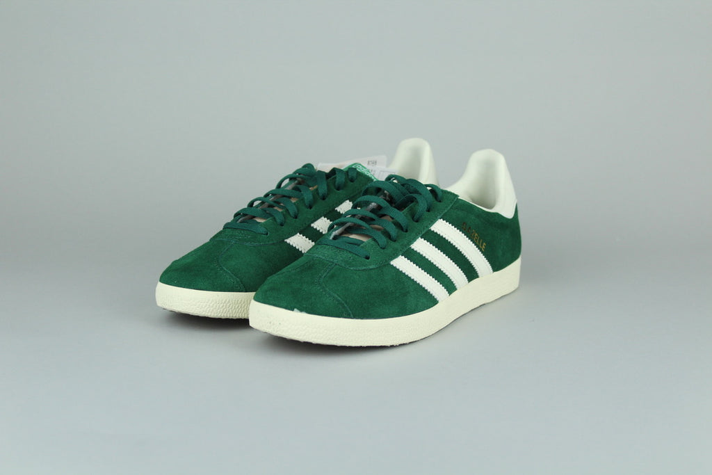 Adidas Gazelle Dark Grey/O White sneakers side view, classic low-top design, grey suede and white accents, retro style, casual athletic footwear, iconic heritage shoe