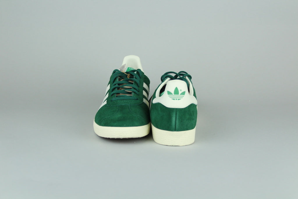 Adidas Gazelle Dark Grey/O White sneakers side view, classic low-top design, grey suede and white accents, retro style, casual athletic footwear, iconic heritage shoe