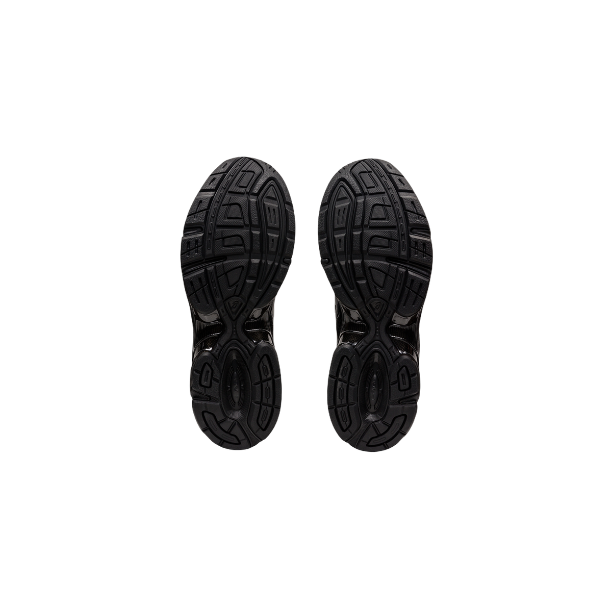 Bottom view of a pair of black Asics Gel-1130 sneakers showing the treaded rubber outsole pattern.