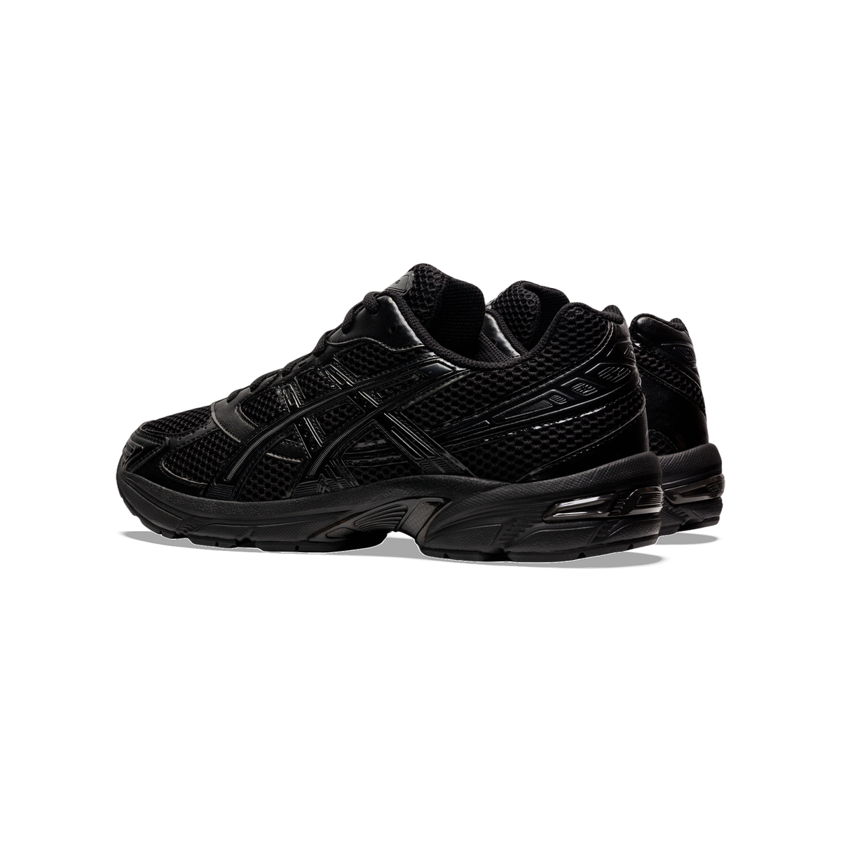 Side view of an all-black Asics Gel-1130 sneaker with mesh upper, tonal overlays, and chunky rubber sole, paired with a second shoe behind it