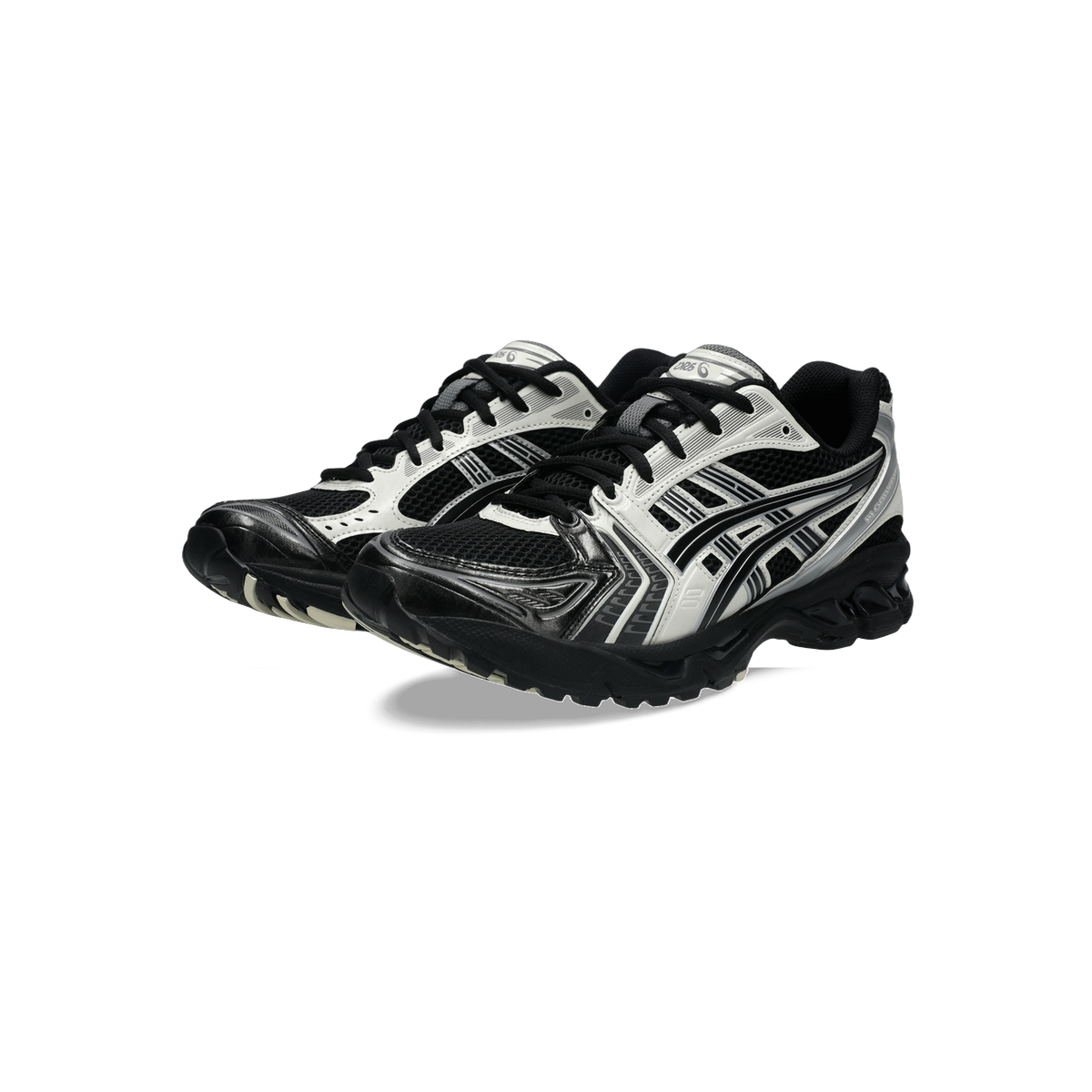 Pair of black and cream Asics Gel-Kayano 14 sneakers shown at an angled front view with mesh uppers and chunky black soles