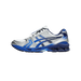 Lateral view of a white and blue Asics Gel-Kayano 14 sneaker with silver overlays, navy trim, and 'The Museum Visitor' text on the heel panel, toe pointing left.