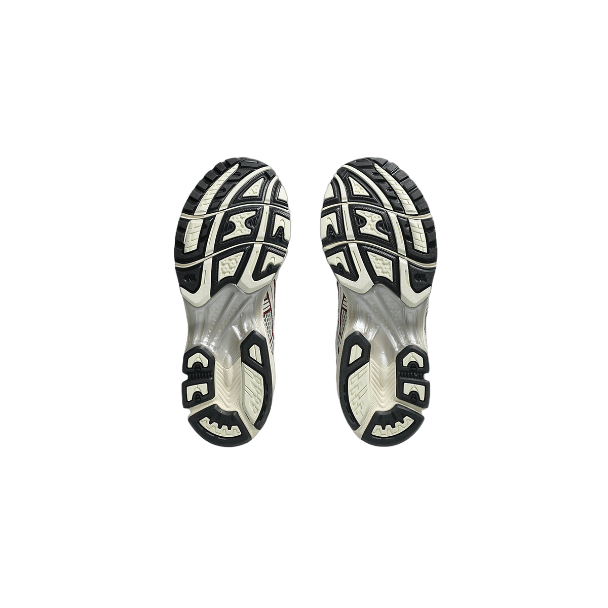 Bottom view of a pair of Asics Gel-Kayano 14 sneakers showing the black and cream tread pattern on both outsoles