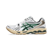 Side view of a white Asics Gel-Kayano 14 sneaker with green mesh overlays, black stripes, tan gum outsole, and a bronze heel panel.
