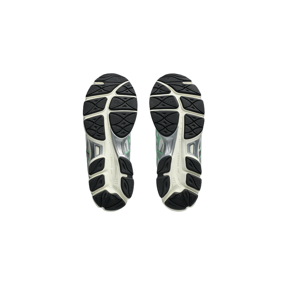 Bottom view of a pair of white Asics Gel-NYC sneakers showing black tread pattern and green accents on the outsole gel unit.
