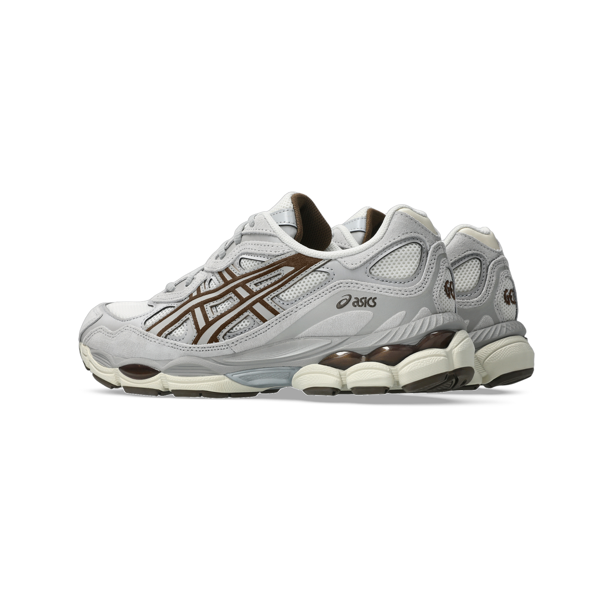 Side view of a grey Asics Gel-NYC sneaker with brown overlay detailing and a cream visible gel cushioning unit in the heel, with a second matching shoe visible behind it