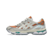 Lateral view of an Asics Gel-NYC sneaker with orange mesh, cream and silver overlays, white laces, and a visible teal gel cushioning unit in the sole.