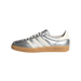 Side view of a silver metallic Adidas Gazelle sneaker with white stripes, white heel tab, and gum rubber sole, toe pointing left.