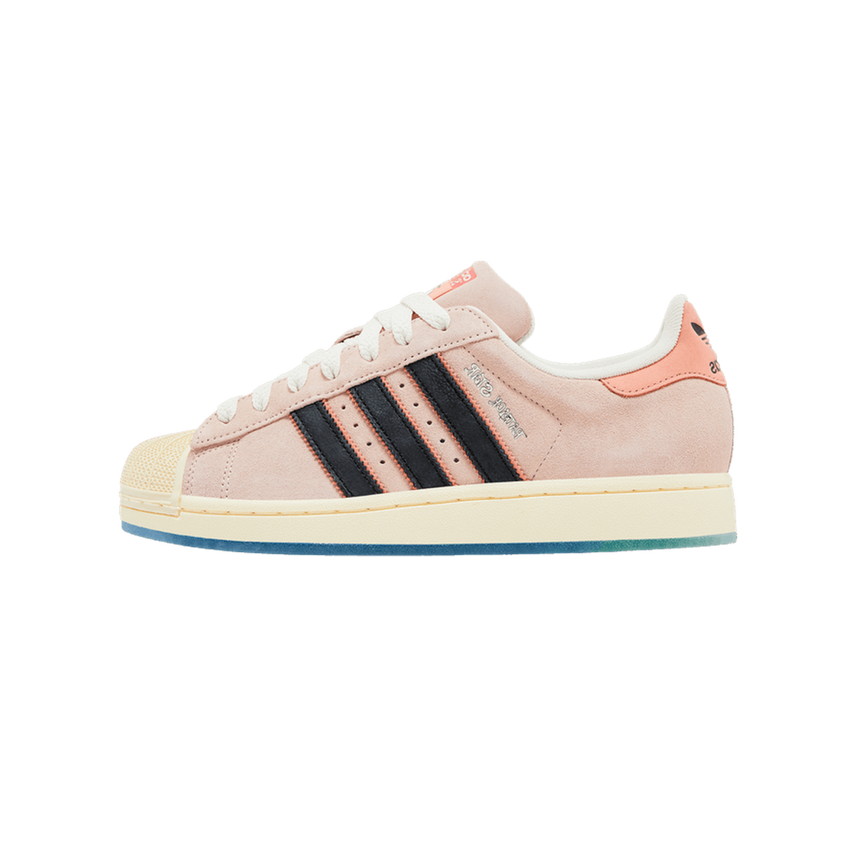 Side view of a pink suede Adidas Superstar sneaker with black stripes, cream shell toe, and coral heel tab, toe pointing left.