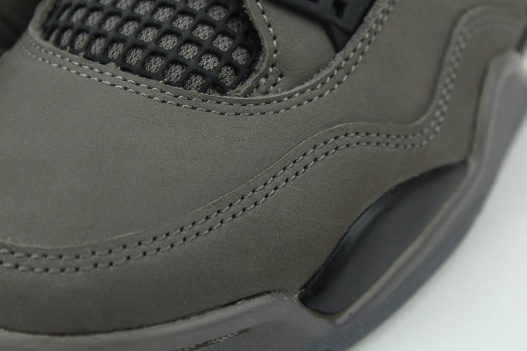 The Air Jordan 4 Cave Stone reimagines the classic silhouette with an earthy nubuck upper in taupe-brown tones, contrasted by bold black mesh and details. Travis Scott vibes.