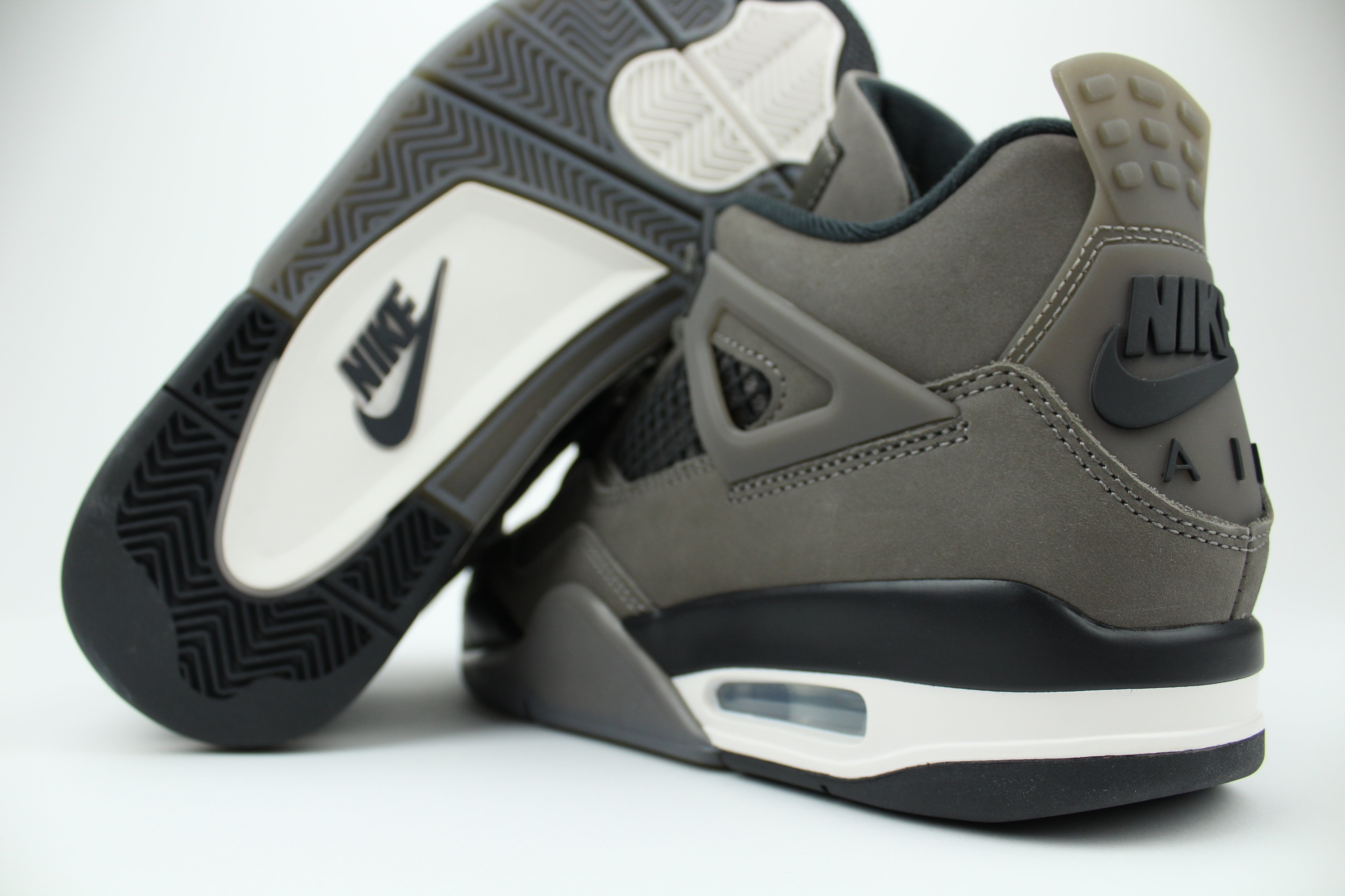 The Air Jordan 4 Cave Stone reimagines the classic silhouette with an earthy nubuck upper in taupe-brown tones, contrasted by bold black mesh and details. Travis Scott vibes.