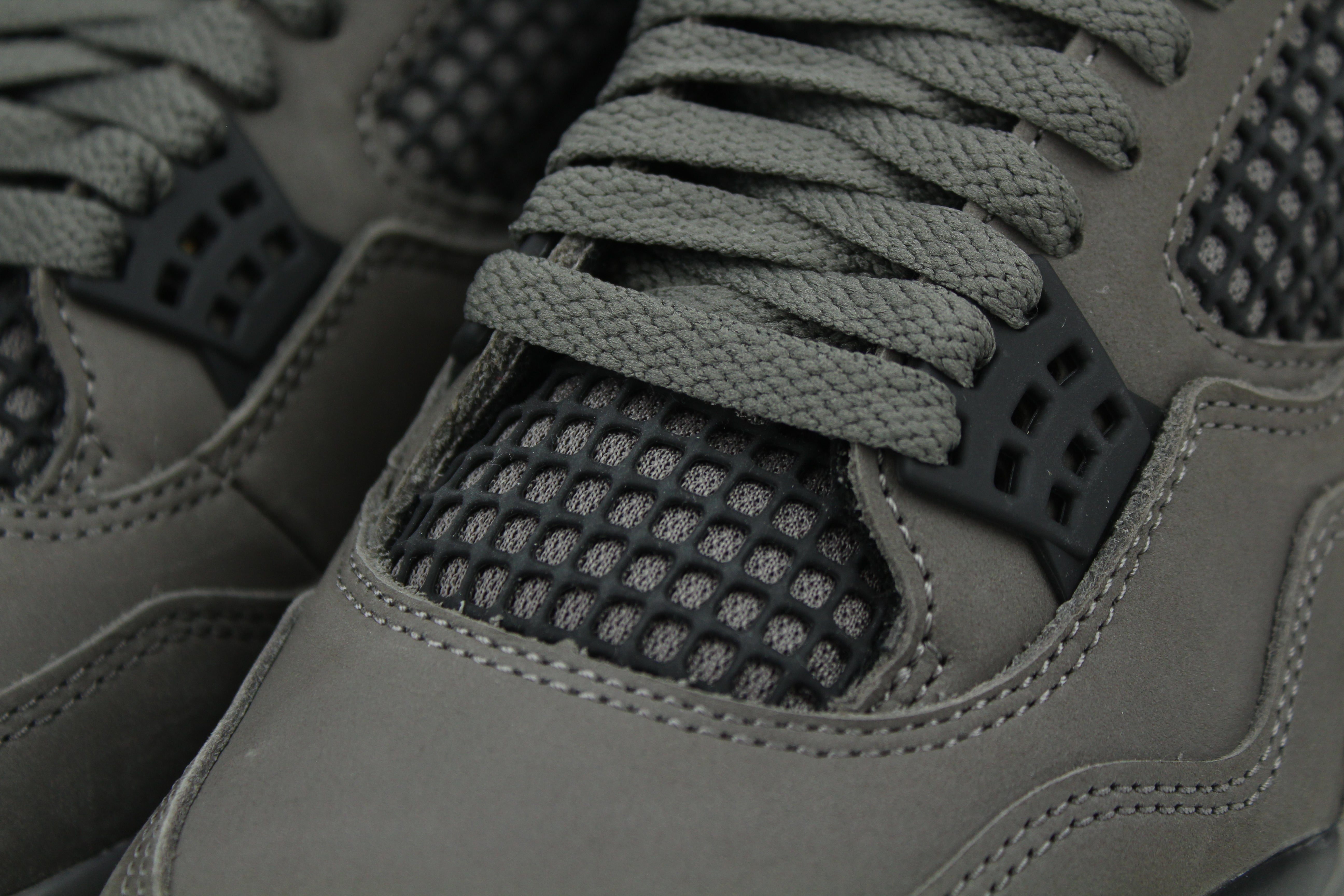 The Air Jordan 4 Cave Stone reimagines the classic silhouette with an earthy nubuck upper in taupe-brown tones, contrasted by bold black mesh and details. Travis Scott vibes.