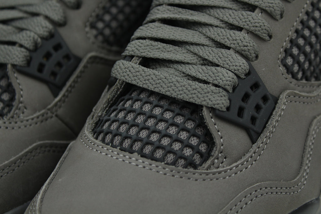 The Air Jordan 4 Cave Stone reimagines the classic silhouette with an earthy nubuck upper in taupe-brown tones, contrasted by bold black mesh and details. Travis Scott vibes.