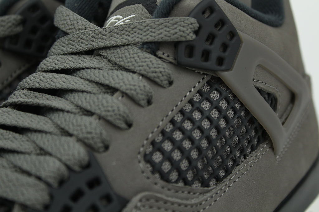 The Air Jordan 4 Cave Stone reimagines the classic silhouette with an earthy nubuck upper in taupe-brown tones, contrasted by bold black mesh and details. Travis Scott vibes.