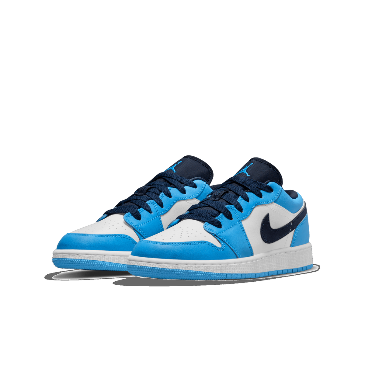 Pair of white and university blue Jordan 1 Low sneakers with navy Swoosh logos and navy laces, angled toward the left