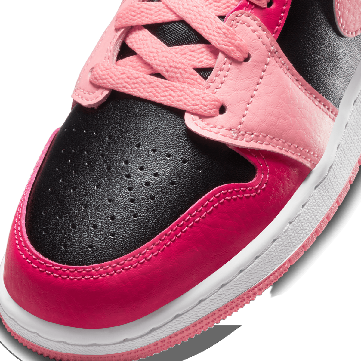 Close-up of a sneaker toe box showing perforated black leather, pink laces and lace panel, and a pink-to-magenta gradient toe cap on a white midsole with pink outsole trim.
