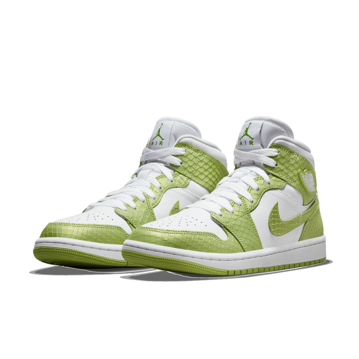 A pair of green and white high-top sneakers with a green snakeskin-textured overlay, shown side by side at a three-quarter angle with toes pointing toward the viewer and to the left, with white laces, Air and Jumpman branding on the tongues, and whit