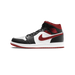 Lateral view of a black, white, and red Air Jordan 1 Mid sneaker with a red Nike swoosh and Wings logo on the ankle, toe pointing left.