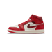 Lateral view of a red and white Air Jordan 1 Mid sneaker with cracked-texture leather panels on the heel and swoosh, red laces, and white midsole with red outsole.