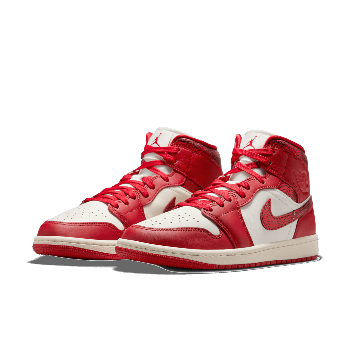 Pair of red and white Jordan 1 Mid high-top sneakers with cracked-texture leather panels on the heel and swoosh, shown at a front three-quarter angle