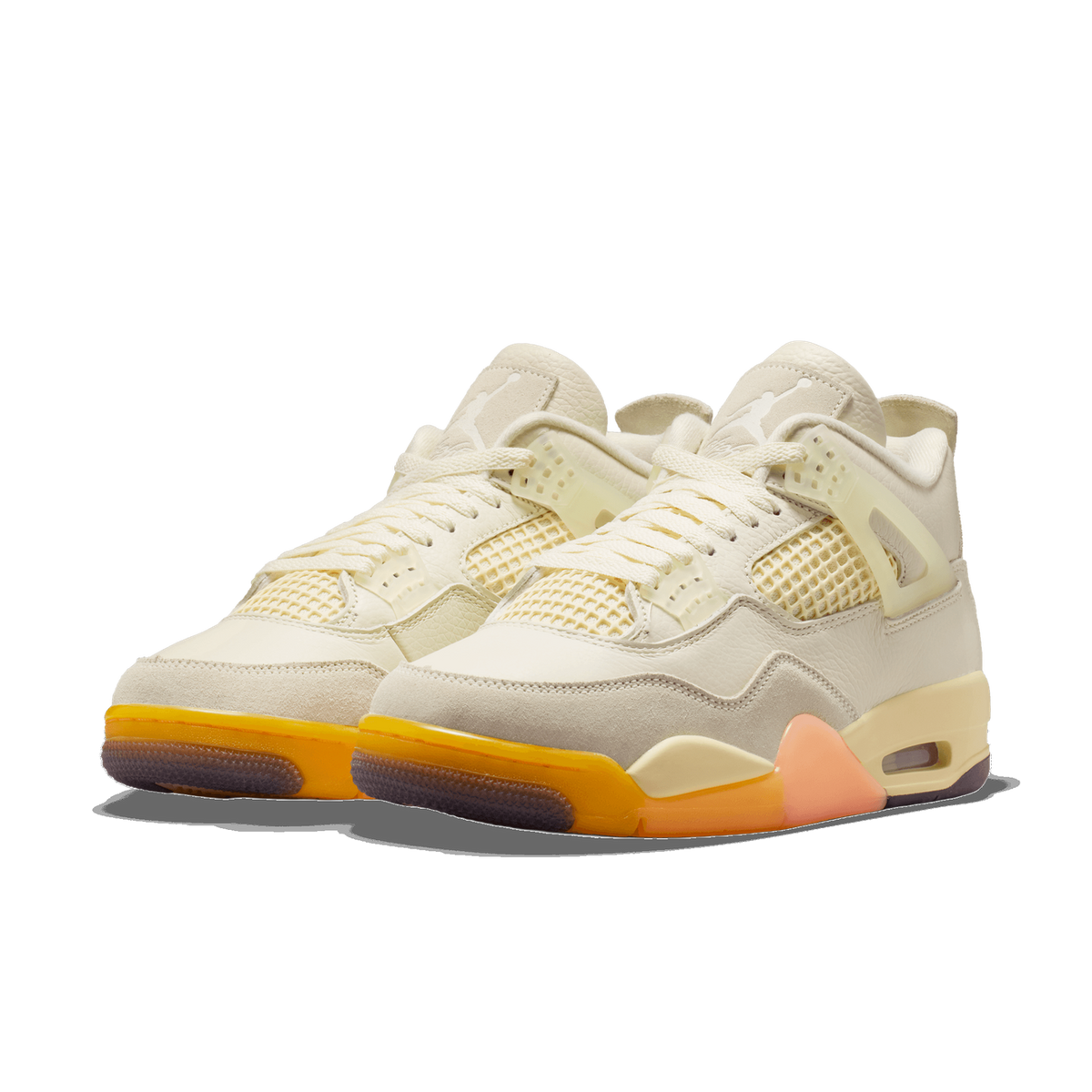 Pair of cream Air Jordan 4 sneakers with mesh side panels, suede mudguards, orange translucent outsoles, and a peach heel tab, angled toward the left.
