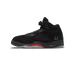 Outside view of a black suede Air Jordan 5 with red shark-tooth midsole detailing, '23' branding, and translucent heel sole.