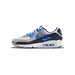 Side view of a Nike Air Max 90 sneaker in white and grey with blue Swoosh and navy heel panel, toe pointing left