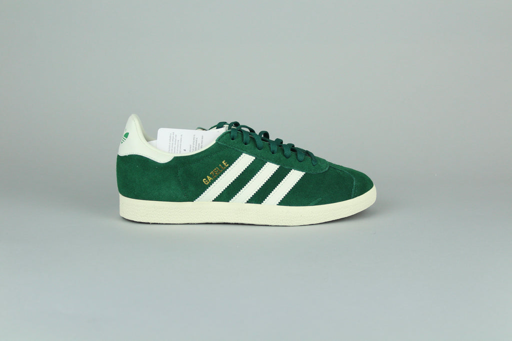 Adidas Gazelle Dark Grey/O White sneakers side view, classic low-top design, grey suede and white accents, retro style, casual athletic footwear, iconic heritage shoe